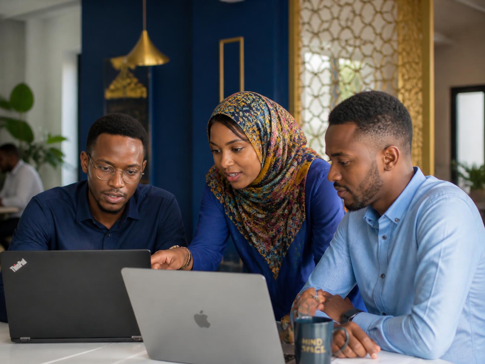 Jeunes entrepreneurs comoriens travaillant ensemble sur des ordinateurs portables